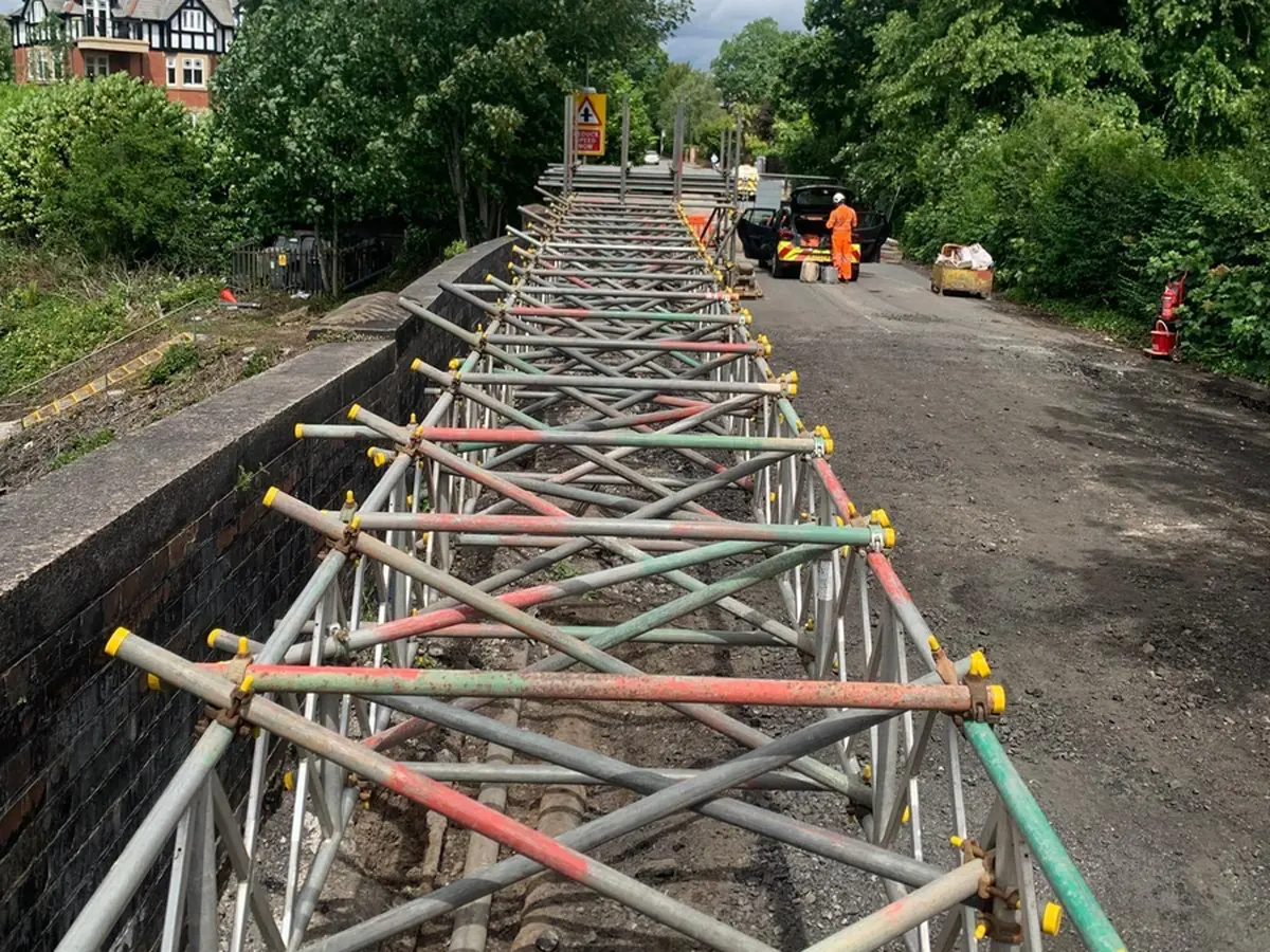 Service support bridge: 750mm unit beams spanning the open deck of a road-over-rail bridge