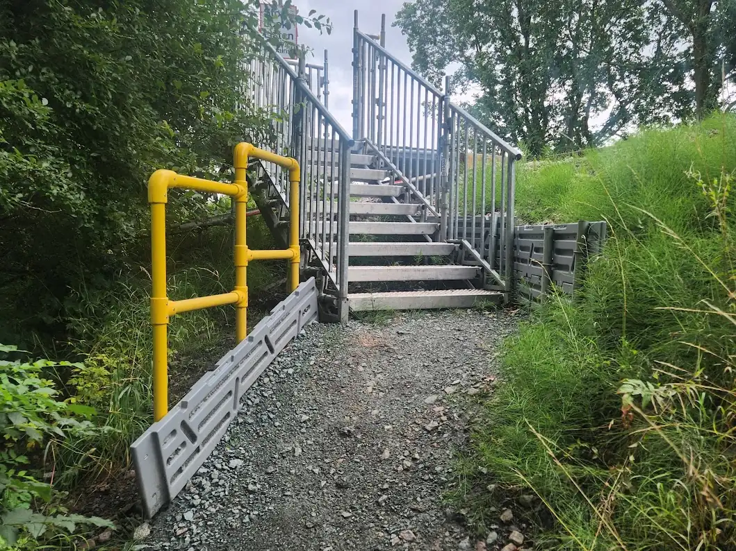 Temporary stair tower with handrails giving access down a railway embankment
